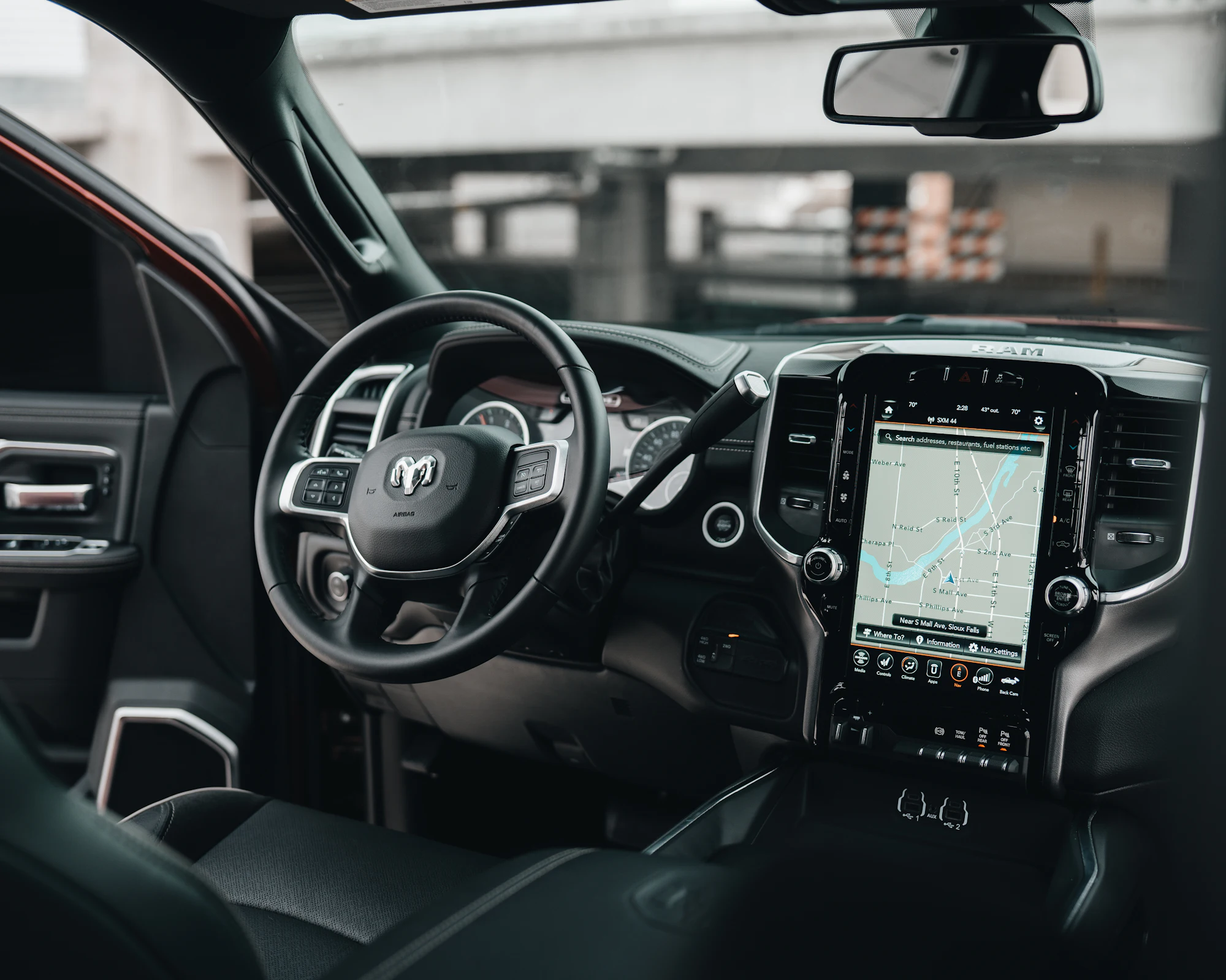 A truck cockpit with a large centre touchscreen, photographed from the passenger seat.