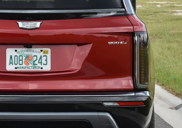 Close-up of the tailgate of a red 2026 Cadillac Vistiq showing the 900E4 badge beside the taillight