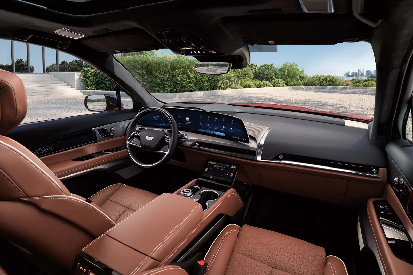 Interior of the 2027 Cadillac Vistiq showing the steering wheel, the wide curved dashboard display and brown leather seats